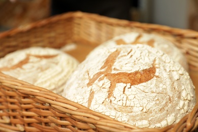 Photo of Wicker tray with fresh loaves of bread in bakery