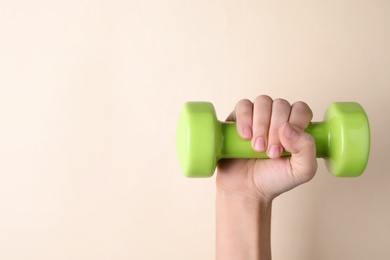 Photo of Woman holding vinyl dumbbell on color background, closeup with space for text