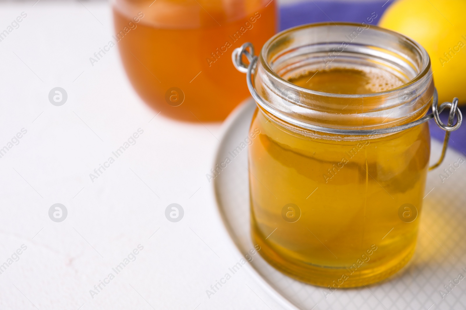 Photo of Tasty aromatic honey on white table, closeup