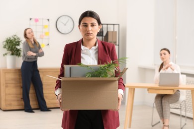 Photo of Unemployment problem. Woman with box of personal belongings in office
