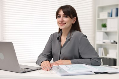 Photo of Portrait of smiling secretary at table in office