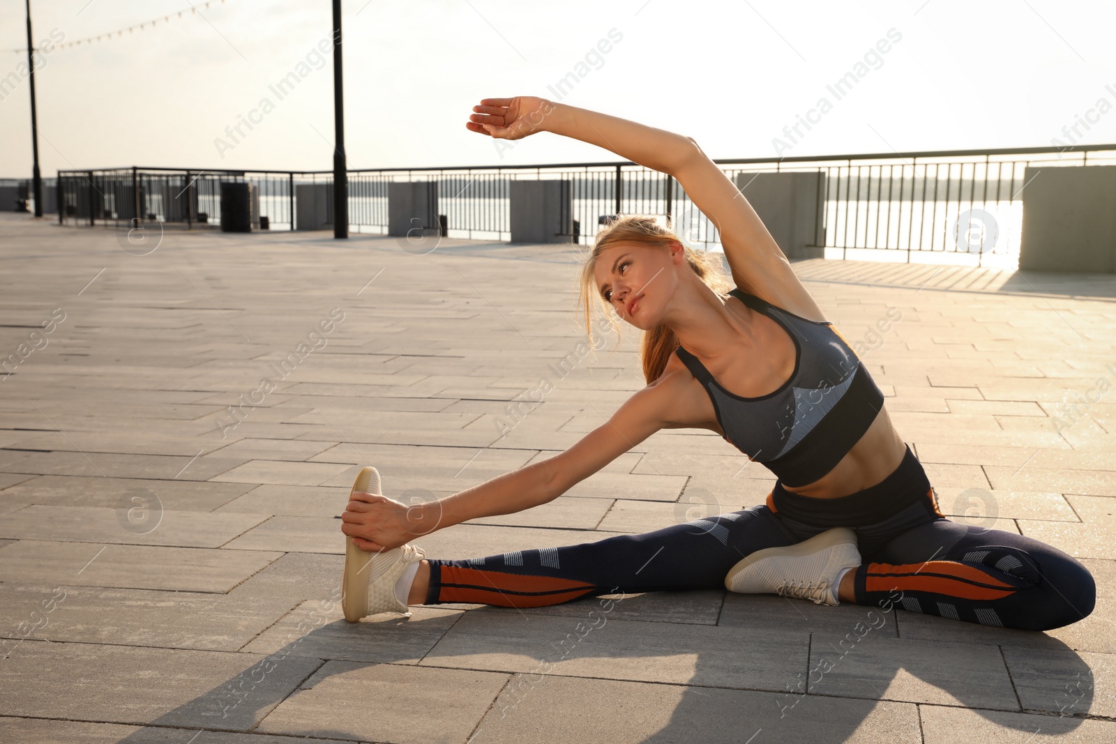 Photo of Beautiful woman in sportswear doing exercises outdoors on sunny day