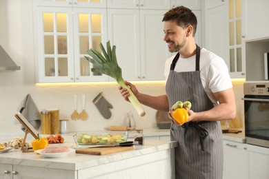 Man making dinner while watching online cooking course via tablet in kitchen