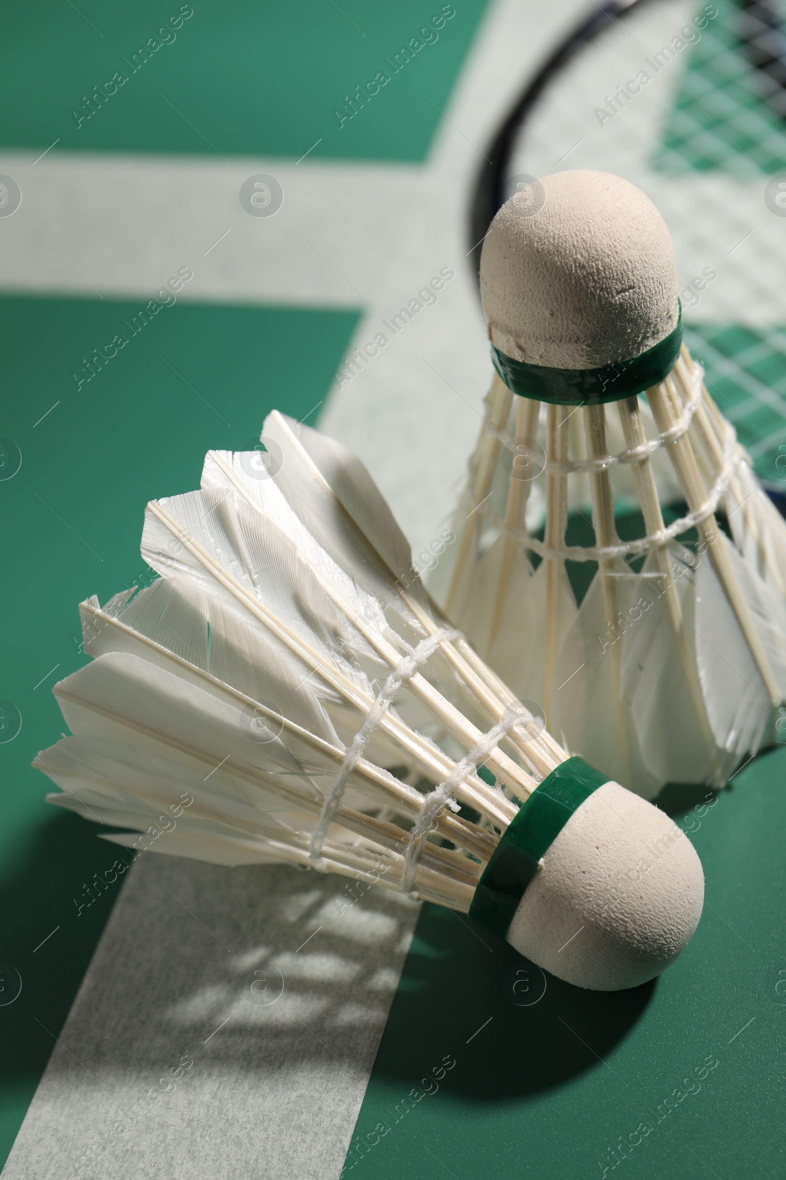 Photo of Two feather badminton shuttlecocks on court, closeup