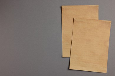 Sheets of old parchment paper on grey background, flat lay. Space for text