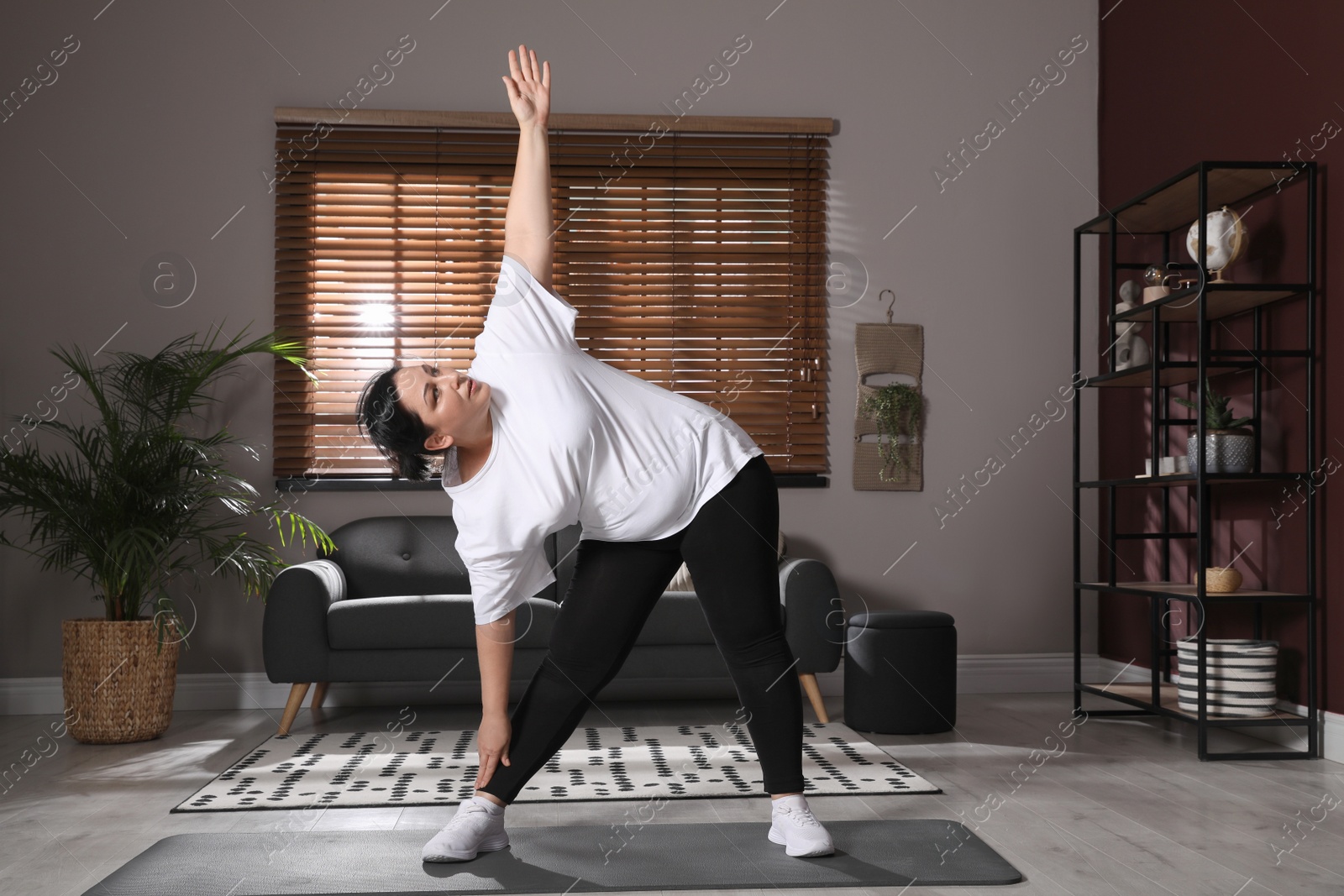 Photo of Overweight mature woman doing exercise at home