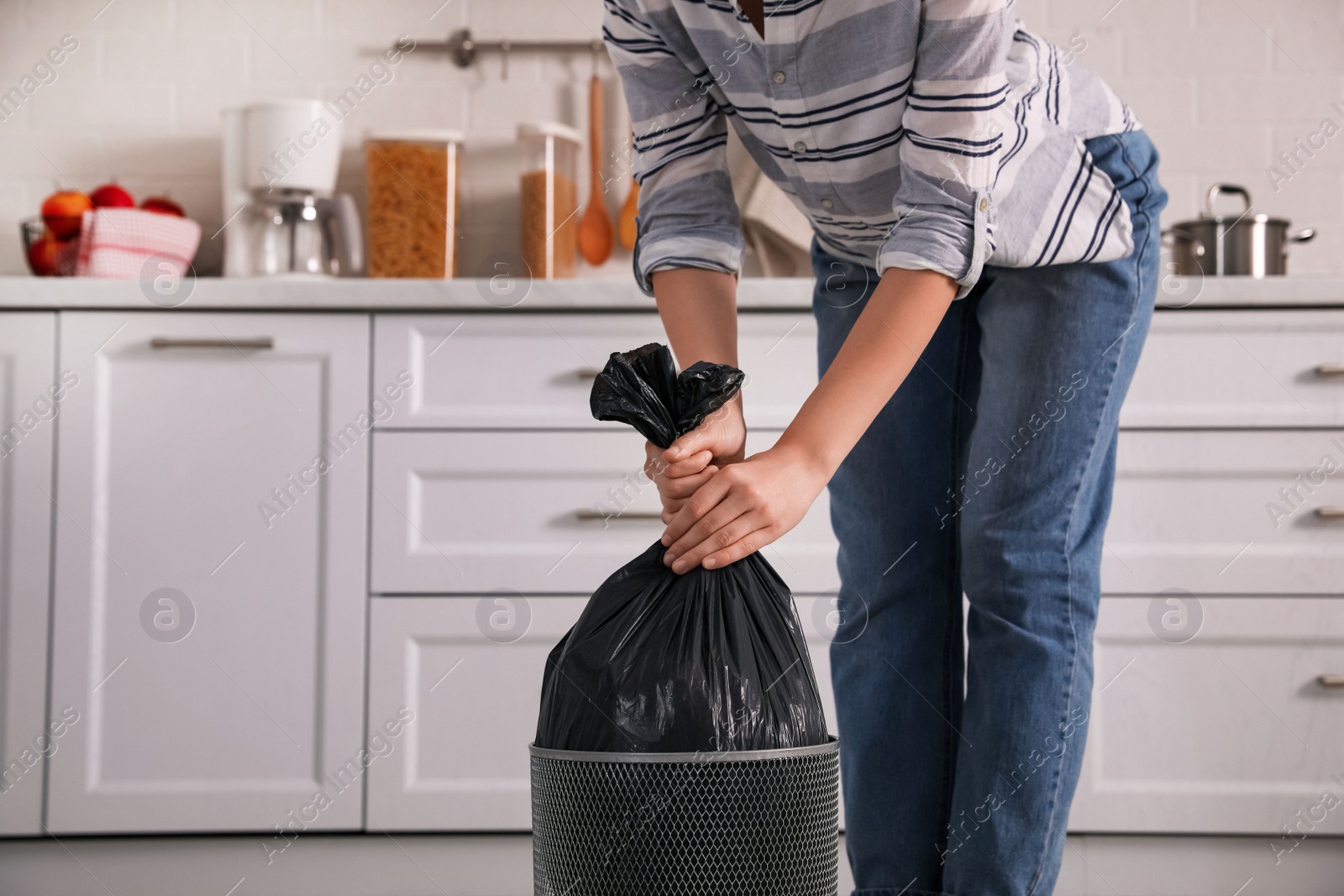 Photo of Woman taking garbage bag out of bin at home, closeup