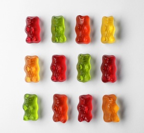 Photo of Delicious color jelly bears on white background, top view