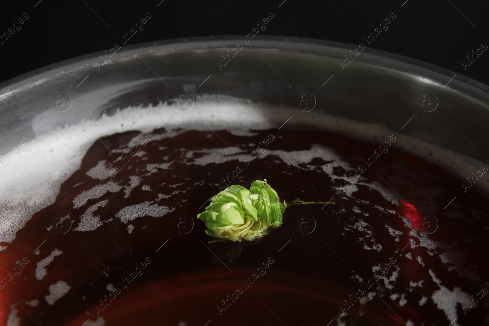 Photo of Beer wort with fresh green hop in pot, closeup