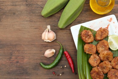 Photo of Delicious fried bananas, fresh fruits and different peppers on wooden table, flat lay. Space for text