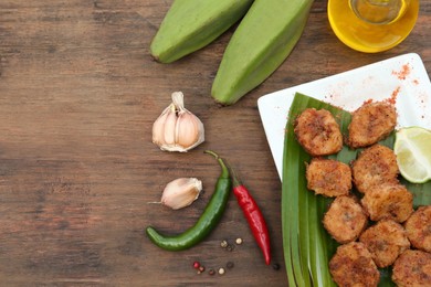 Delicious fried bananas, fresh fruits and different peppers on wooden table, flat lay. Space for text