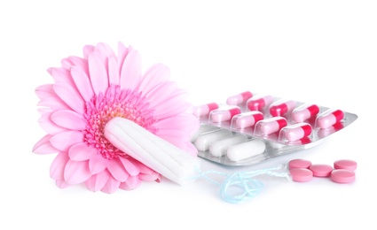 Hygienic tampons, pills and flower on white background. Gynecology concept