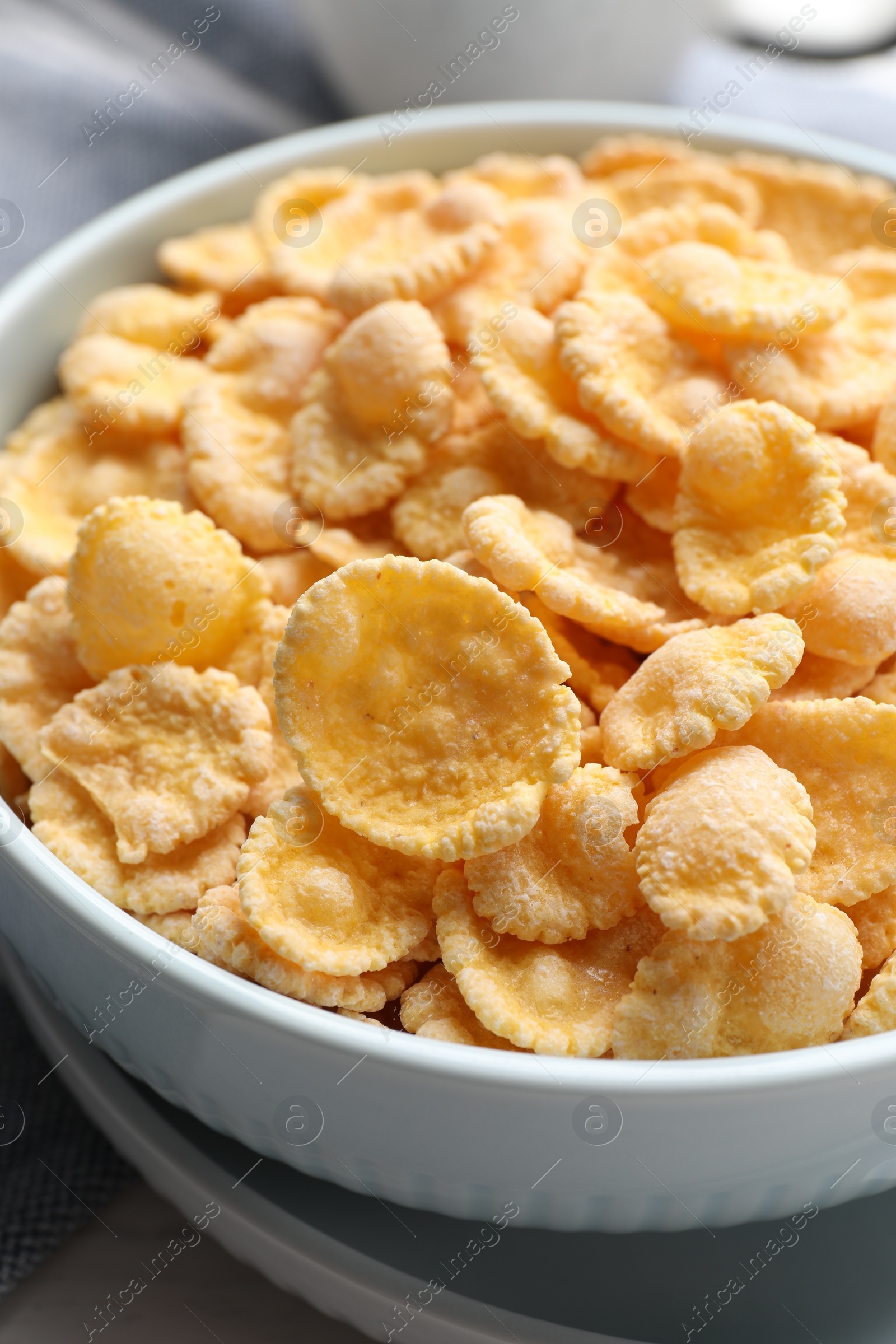 Photo of Bowl of tasty corn flakes on table, closeup