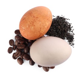 Photo of Naturally painted Easter eggs on white background, top view. Tea and coffee beans used for coloring