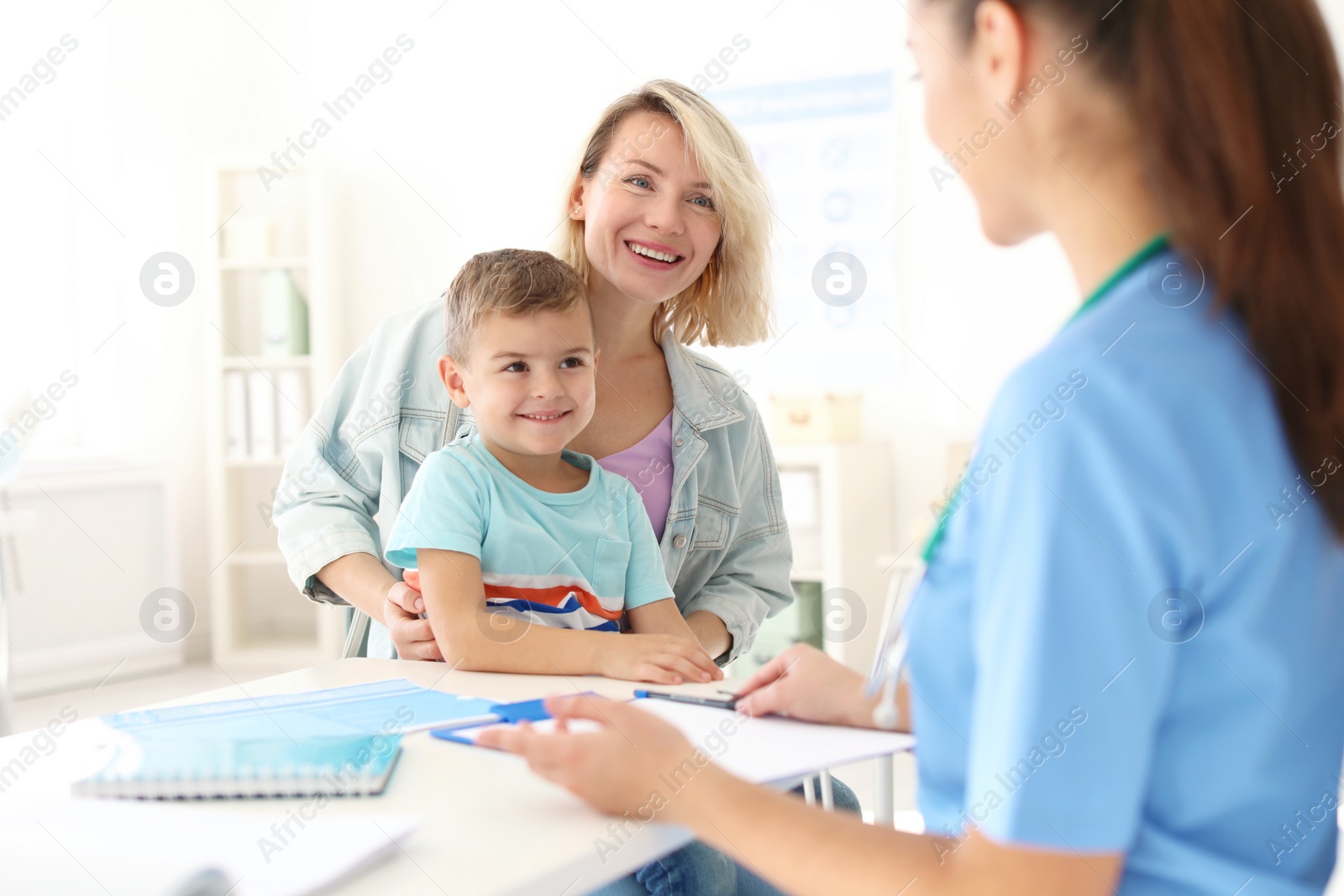 Photo of Little boy with mother visiting children's doctor in hospital