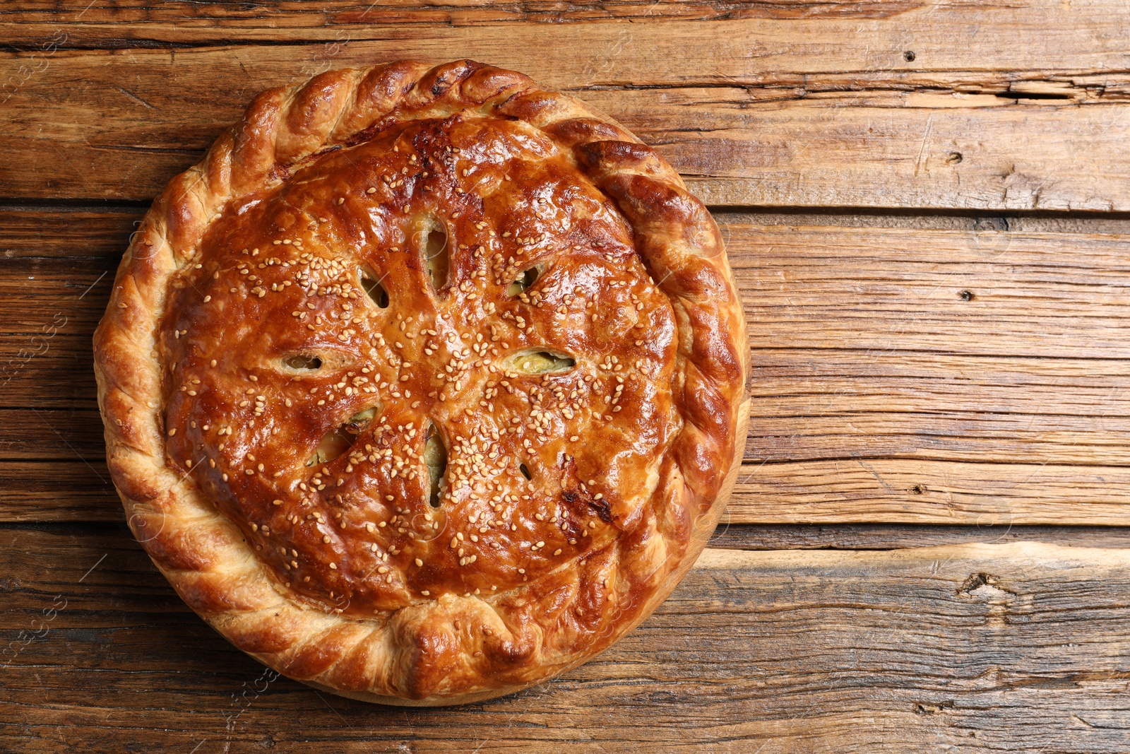 Photo of Tasty homemade pie with filling on wooden table, top view. Space for text