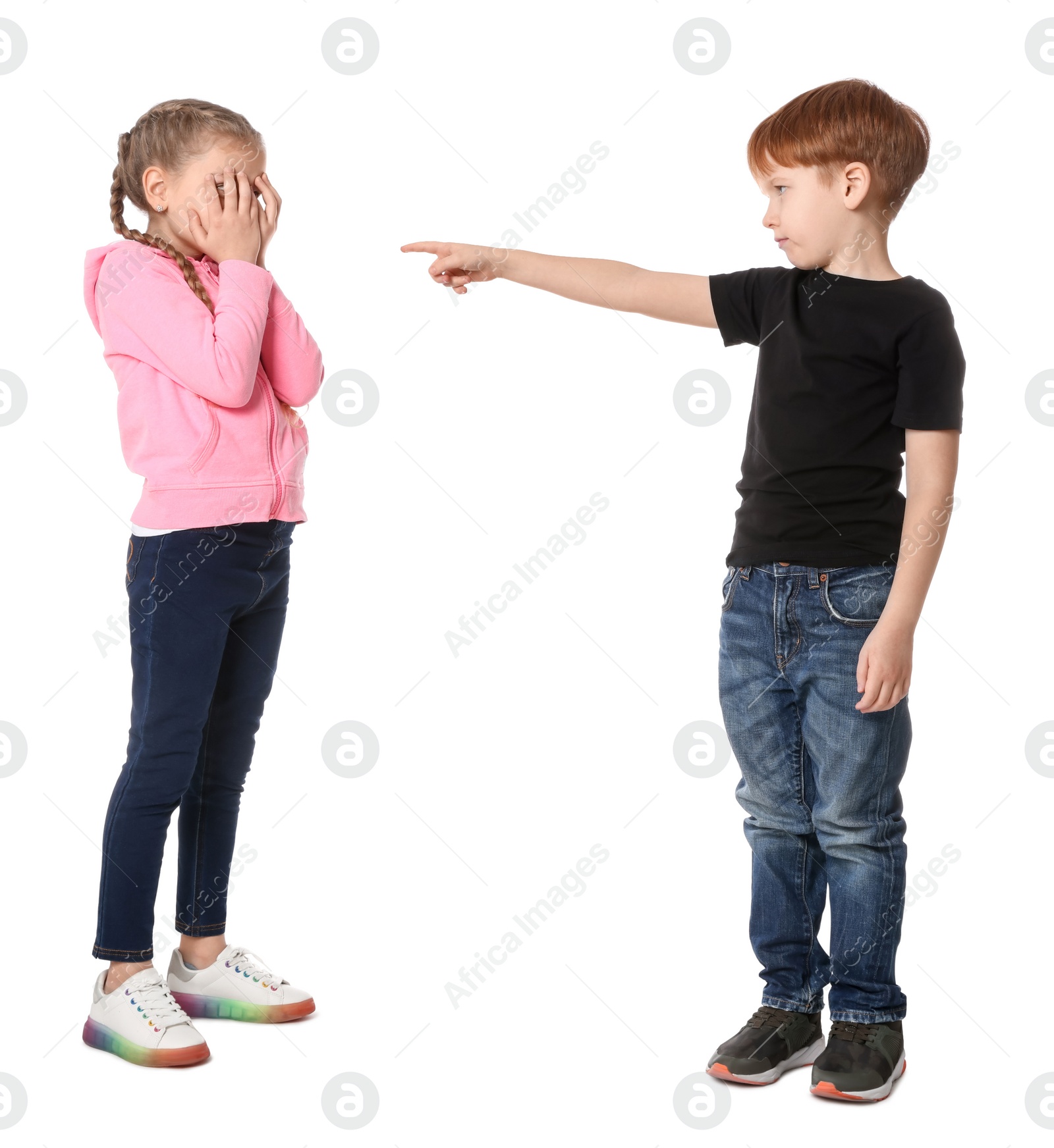 Photo of Boy pointing at upset girl on white background. Children's bullying