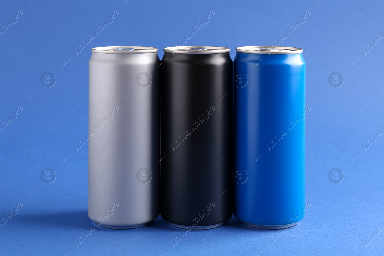 Photo of Energy drinks in colorful cans on blue background