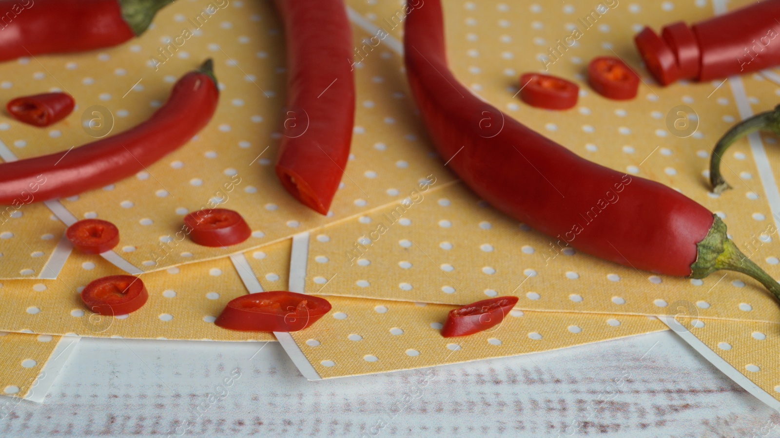 Photo of Pepper plasters and chili on white wooden table, closeup