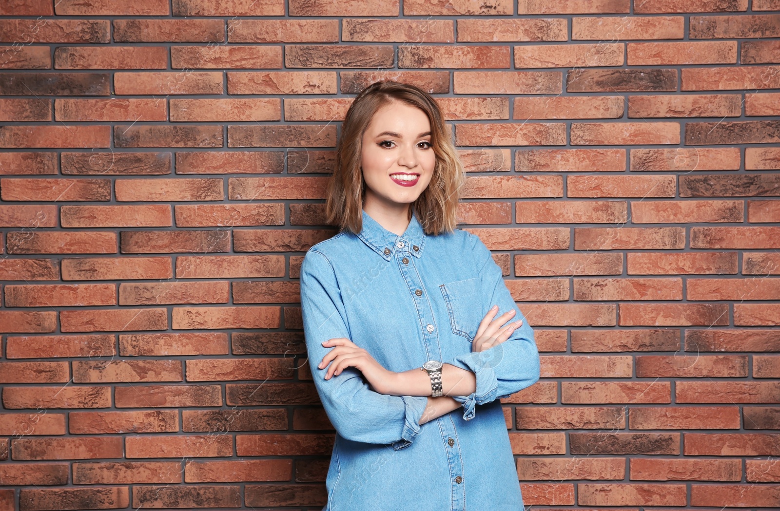 Photo of Beautiful young woman posing on brick wall background