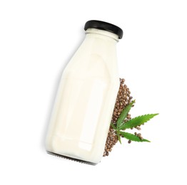 Glass bottle of hemp milk, leaf and seeds on white background, top view
