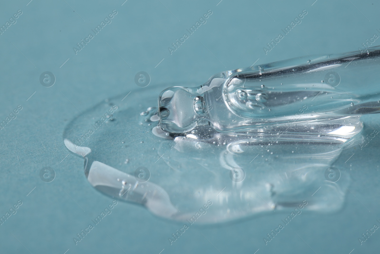Photo of Pipette with cosmetic serum on light blue background, closeup. Space for text