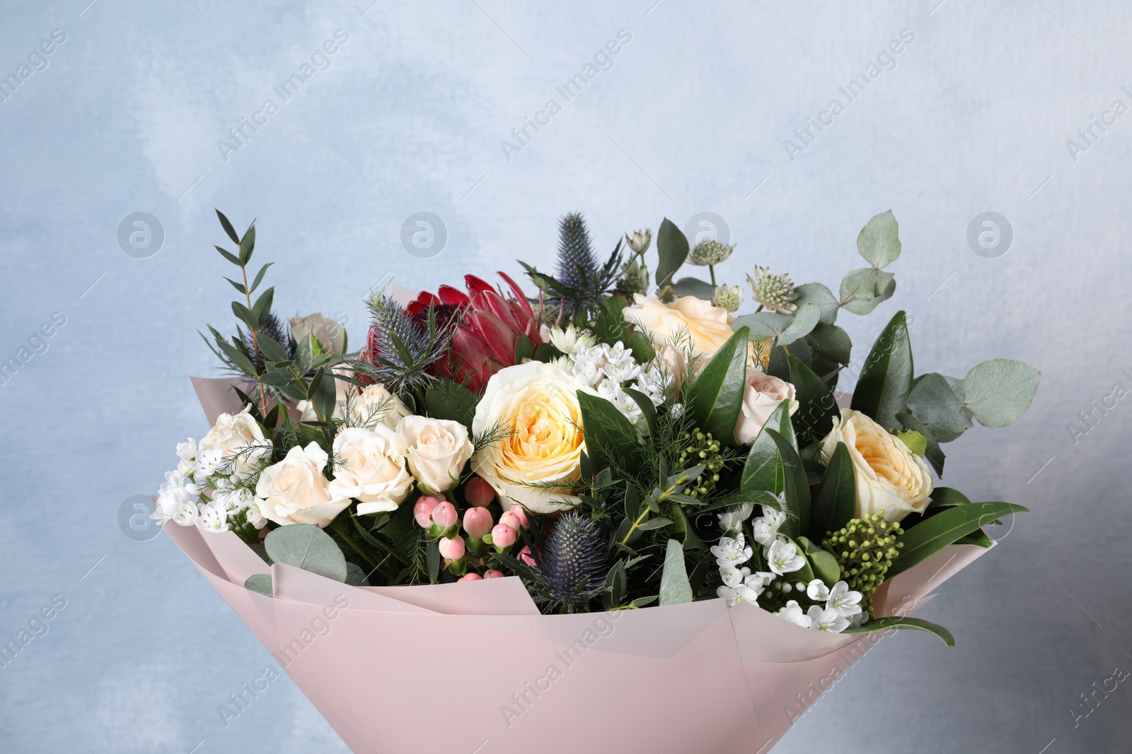Photo of Beautiful bouquet with roses on light blue background