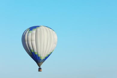 Photo of Beautiful view of hot air balloon in blue sky. Space for text