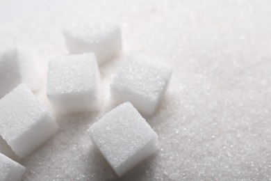 Photo of Different types of white sugar as background, closeup. Space for text