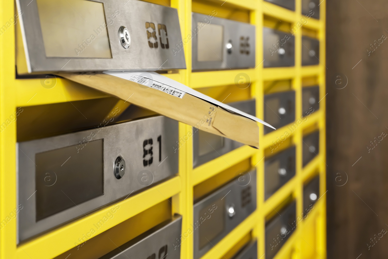 Photo of Metal mailboxes with keyholes, numbers and correspondence in post office, closeup