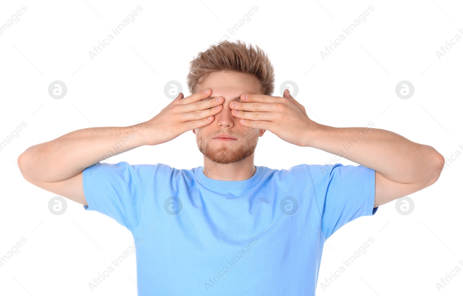 Photo of Young man being blinded and covering eyes with hands on white background