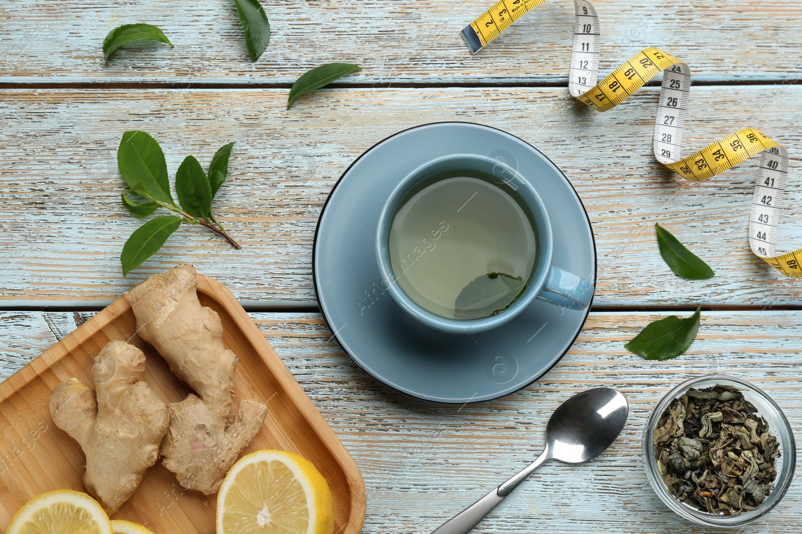 Photo of Flat lay composition with cup of diet herbal tea on light wooden background