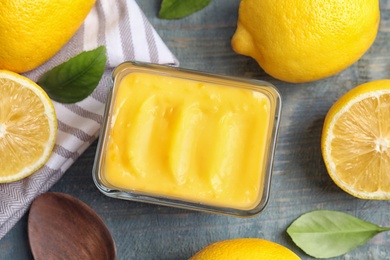 Delicious lemon curd in bowl on wooden table, flat lay