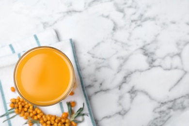 Photo of Delicious sea buckthorn juice on white marble table, top view. Space for text
