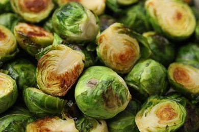 Photo of Delicious roasted Brussels sprouts as background, closeup