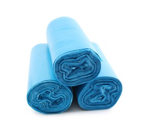 Photo of Rolls of light blue garbage bags isolated on white