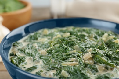 Photo of Tasty spinach dip in bowl on table, closeup