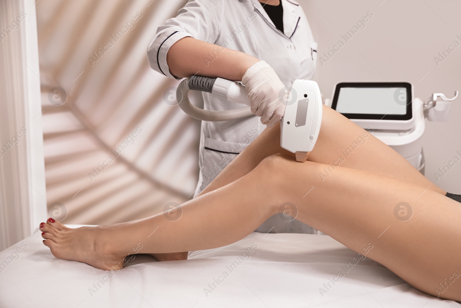 Photo of Woman undergoing laser epilation procedure in beauty salon, closeup