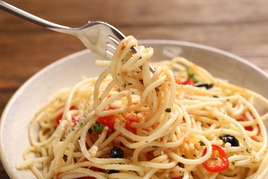 Photo of Eating delicious pasta with tomatoes and parmesan cheese at table, closeup