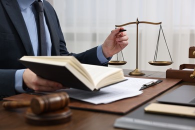 Lawyer working with documents at wooden table indoors, closeup