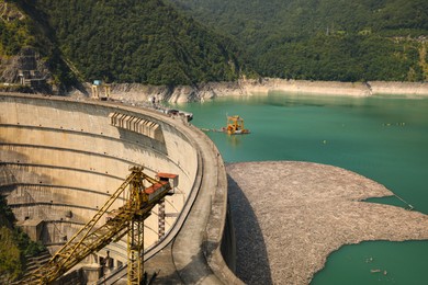 BATUMI, GEORGIA - AUGUST 13, 2022: Tower crane and hydroelectric power station in mountains