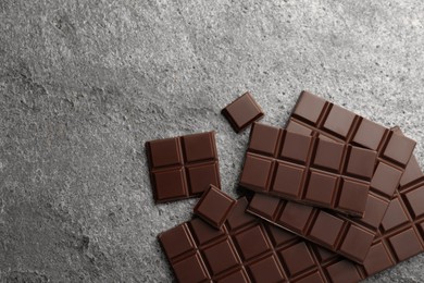 Photo of Delicious dark chocolate on grey table, flat lay. Space for text