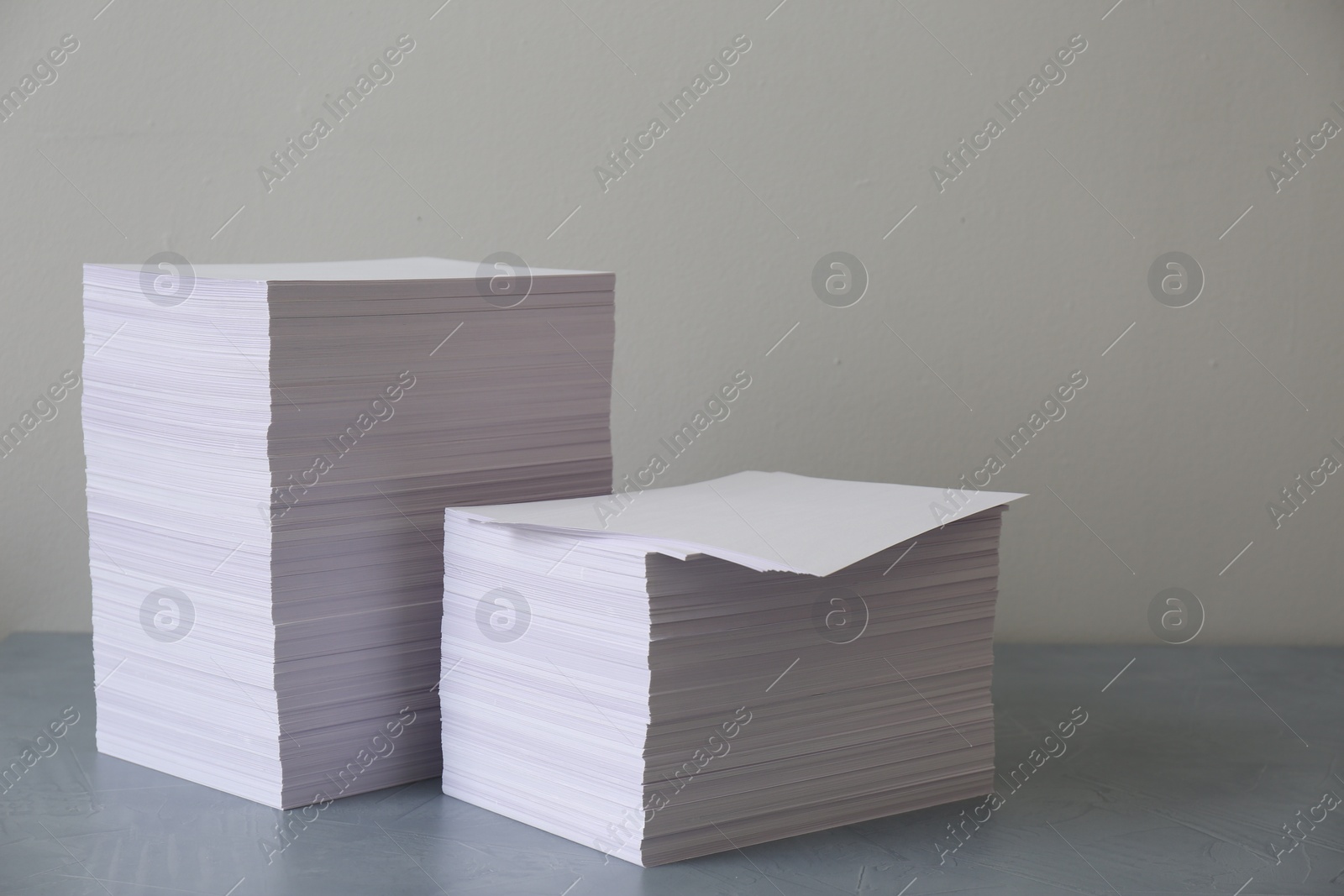 Photo of Stacks of paper sheets on grey table