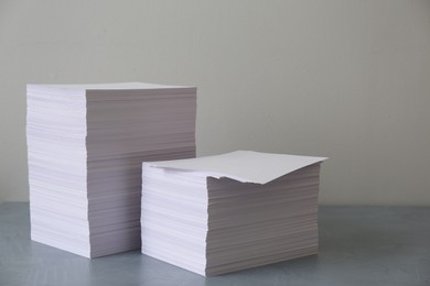 Photo of Stacks of paper sheets on grey table