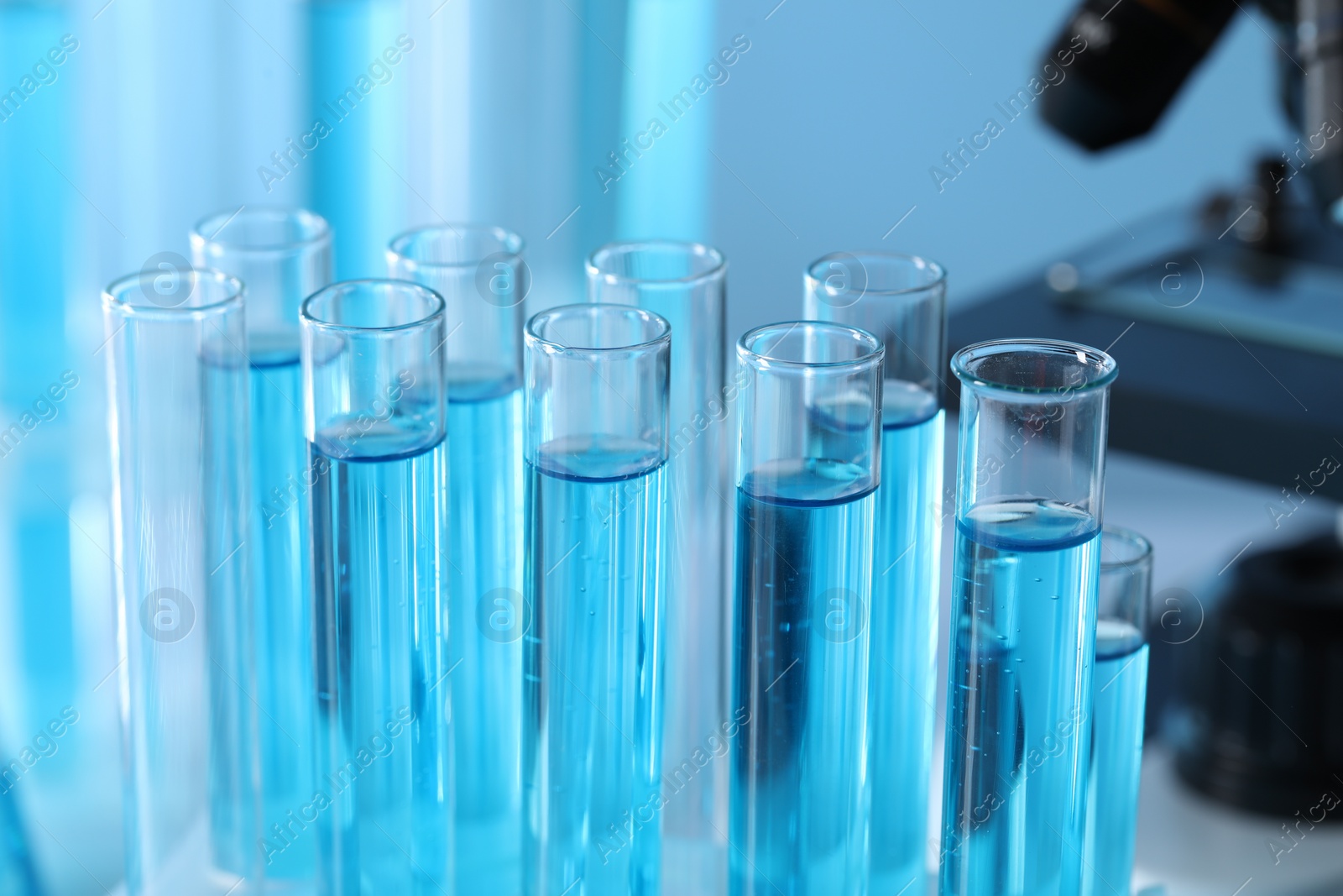 Photo of Test tubes with light blue liquid in laboratory, closeup