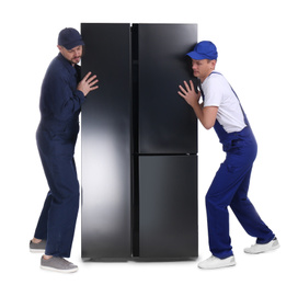 Professional workers carrying refrigerator on white background