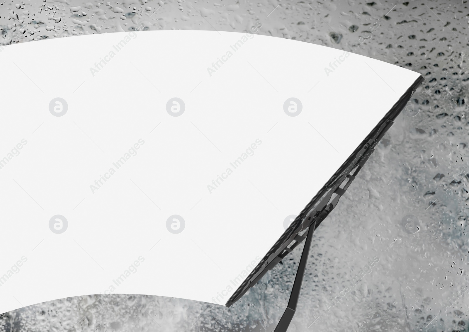 Image of Car windshield wiper cleaning water drops from glass