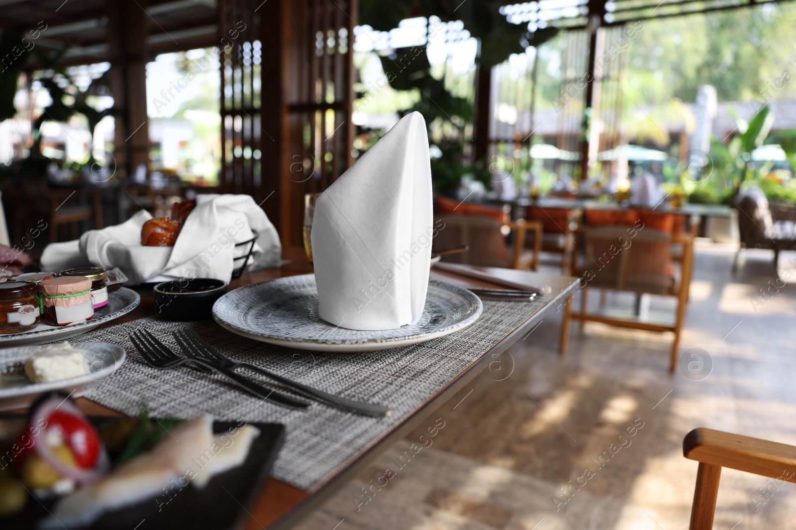 Photo of Delicious food, dishware and cutlery on table in cafeteria, closeup