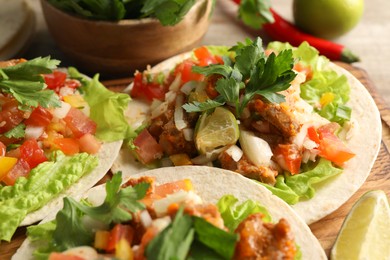 Photo of Delicious tacos with vegetables, meat and lime on table, closeup