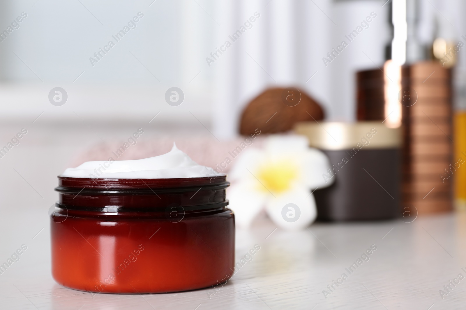 Photo of Jar of body care product on table against blurred background. Space for text